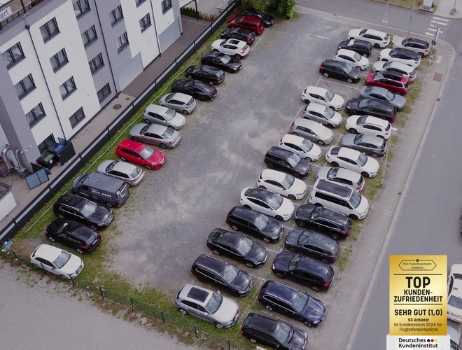 Parking Mein-Flughafenparkplatz-Frankfurt P3. Ujęcie z góry na rząd zaparkowanych samochodów obok budynku, teren utwardzony.