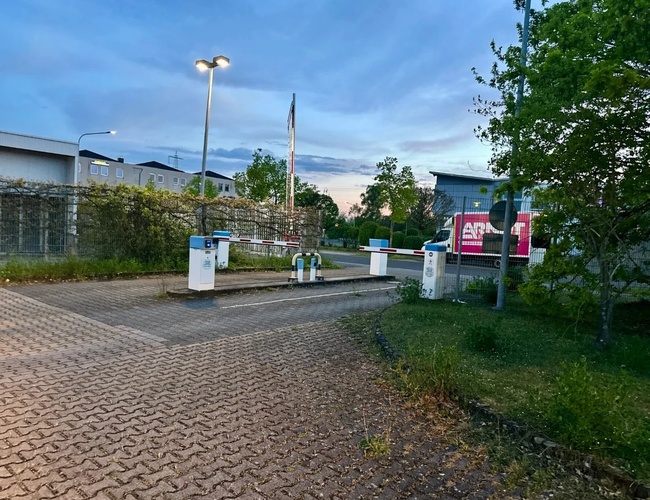 Szlabany służące wjazdowi na parking, dookoła drzewa