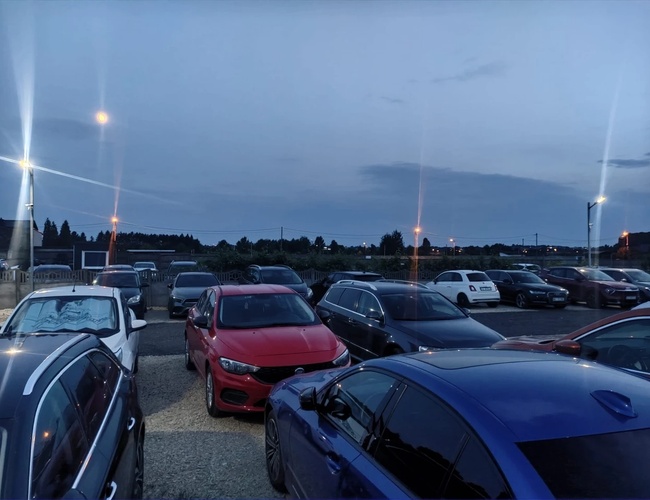 Plac parkingowy wraz z zaparkowanymi pojazdami z innej strony