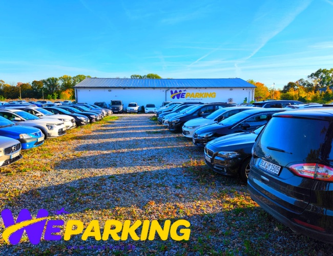 Rząd zaparkowanych samochodów na otwartym parkingu WE Parking w słoneczny dzień.