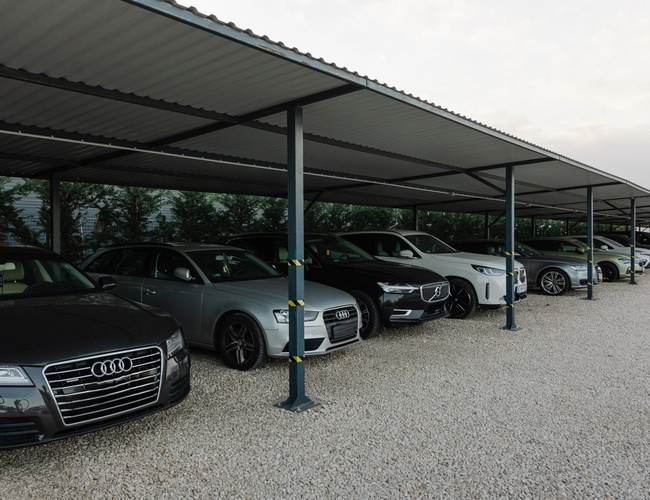 Samochody klientów zaparkowane pod solidnym zadaszeniem na parkingu lotniskowym