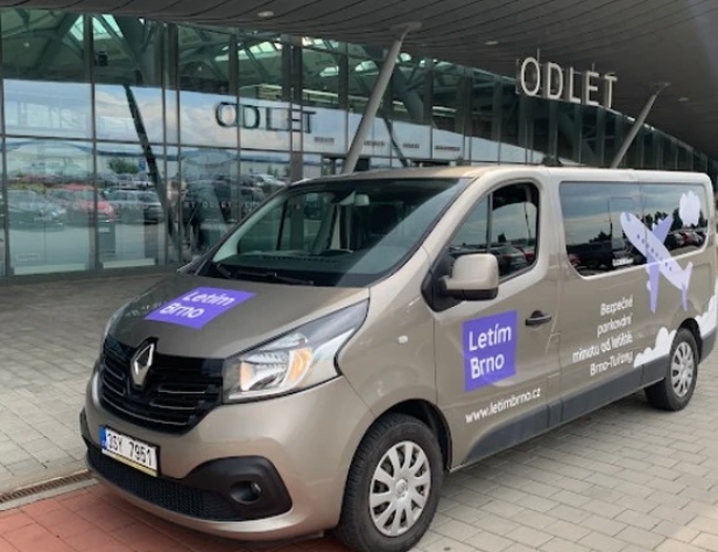 Parking Letim Brno II – na terenie odlotów stoi zaparkowany bus transferowy z oznaczeniem na boku wskazującym nazwę parkingu. W tle teren lotniska.