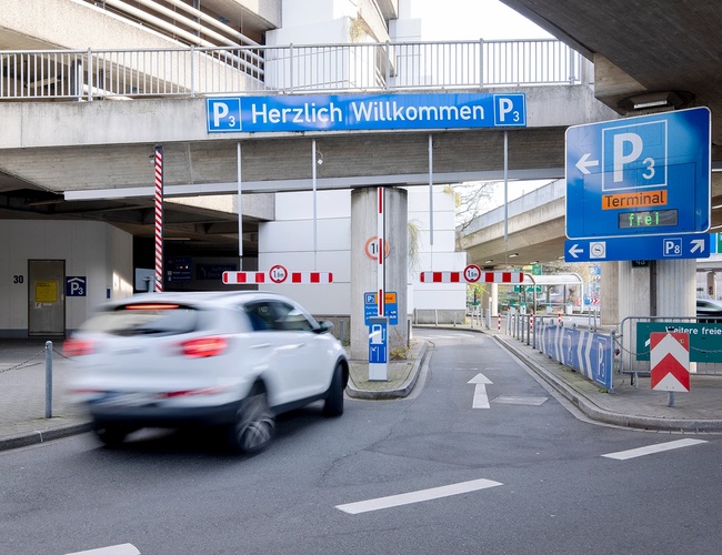 Samochód wjeżdżający na parking P3 przez oznakowany wjazd ze szlabanem, znajdujący się bezpośrednio przy terminalu.