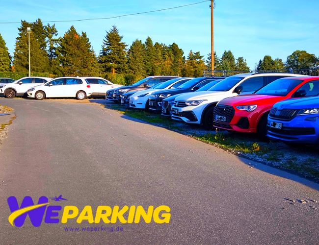 Samochody ustawione w równym rzędzie na zewnętrznym placu parkingowym WE Parking.