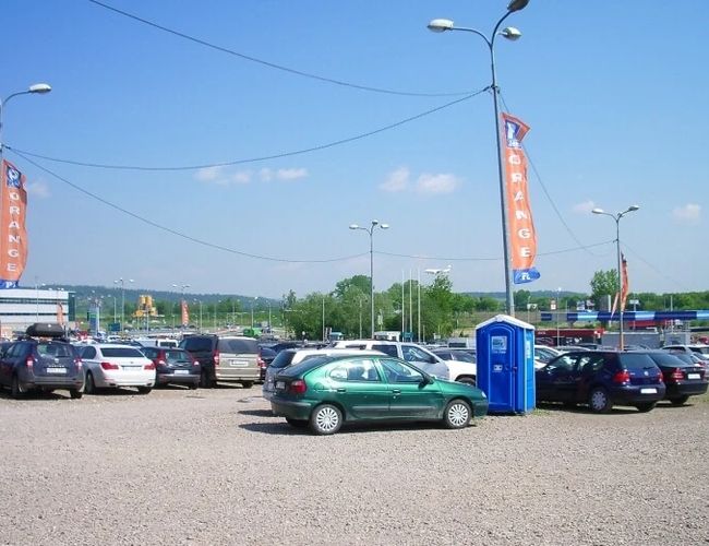 Orange Parking P3 – Parking jest nieutwardzony. Stoją na nim zaparkowane samochody. Na terenie jest przenośna toaleta.