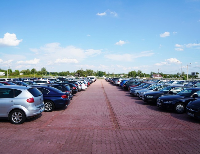 MEGA Parking - Gran espacio exterior con coches aparcados. Aparcamiento pavimentado con adoquines, ubicado al aire libre.