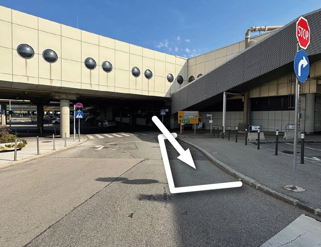 Parking Parktiger Transfer - Camino con señalización de flechas. Señales de STOP y giro obligatorio visibles. El área está pavimentada.