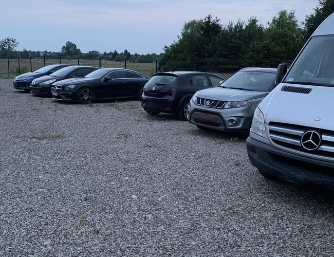 A1 Parking Max – Na štrkovom dvore stojí niekoľko áut. Areál je oplotený sieťou. V pozadí sú vidieť stromy a otvorený priestor.