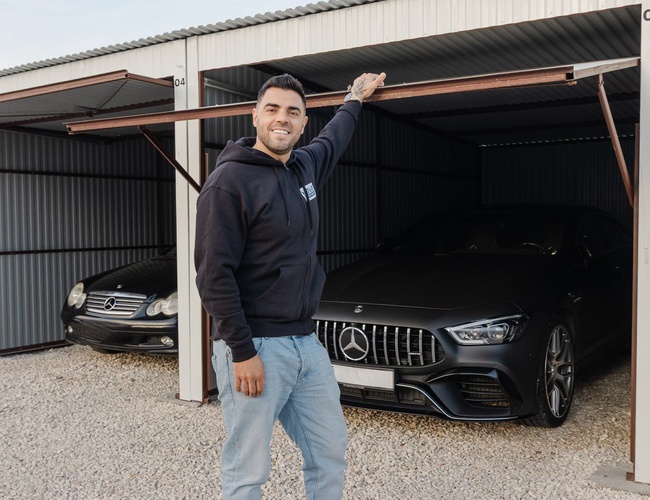 Pracownik parkingu prezentujący zadaszone miejsce postojowe na terenie obiektu
