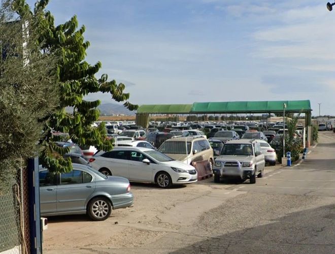 A Drimo Park Valet parkolóban sok autó áll. A terület nyitott. A parkoló mélyén tetőfedett részek találhatók.
