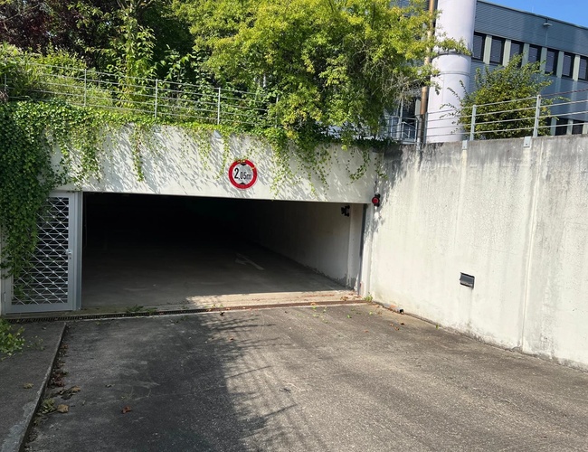 Sun Park Airport Parking Garage - Wejście do garażu jest niskie. Ograniczenie wysokości wynosi 2,05 metra. Ściany pokrywa zielony bluszcz.