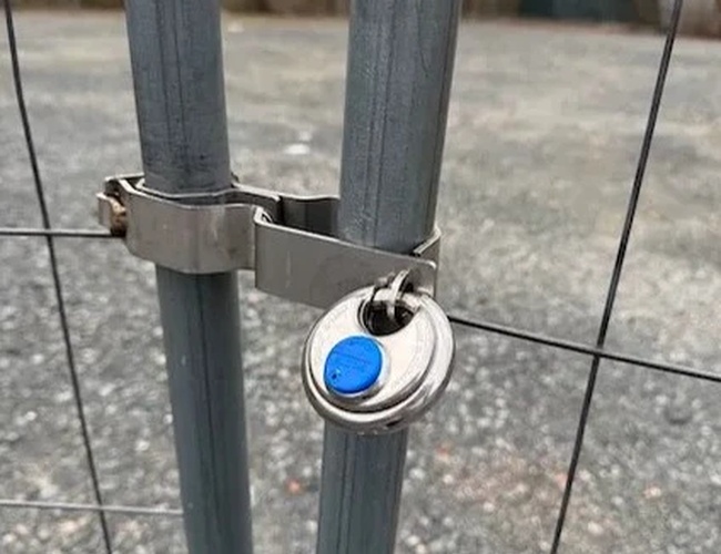 Parkovanie ParkPoint24 Valet - Oplotenie zabezpečené zámkom. Na pozadí viditeľné prázdne miesto. Atmosféra je pokojná a uprataná.