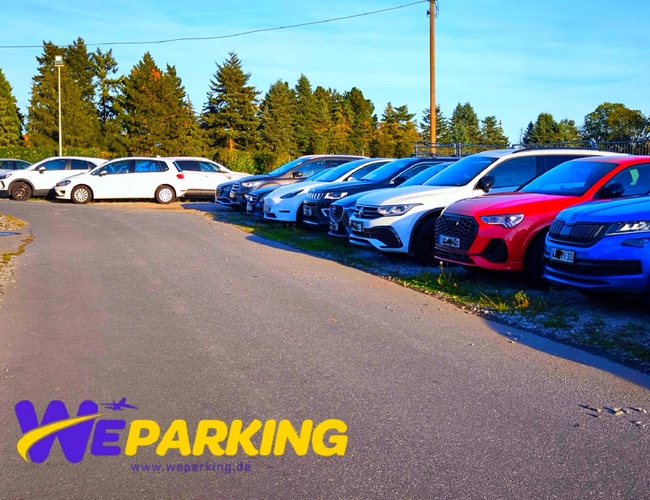 Samochody ustawione w równym rzędzie na zewnętrznym placu parkingowym WE Parking.