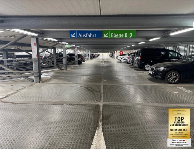 Parking Mein-Flughafenparkplatz-Frankfurt ShortWay – wielopiętrowy budynek parkingowy. Jest noc, widać oświetlenie i samochody.