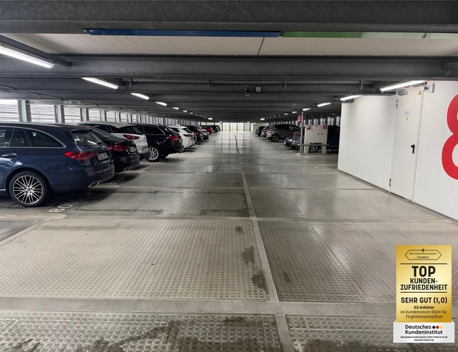 Parking Mein-Flughafenparkplatz-Frankfurt ShortWay – wielopiętrowy budynek parkingowy. Jest noc, widać oświetlenie i samochody.