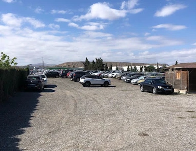 Sunline Parking Outdoor Valet - Parkovanie na spevnenej ploche. Vozidlá stoja v rovných radoch. Pozemok je otvorený, bez viditeľných ohrád.