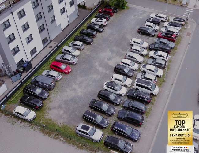 Parking Mein-Flughafenparkplatz-Frankfurt P3. Ujęcie z góry na rząd zaparkowanych samochodów obok budynku, teren utwardzony.