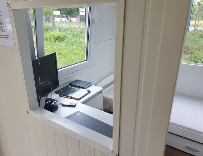 Parkovanie Park&Fly - Kancelárske priestory s pracovným stolom a počítačom. Vedľa na stole leží kalkulačka a poznámkový blok. Na pozadí je vidieť zelené prostredie za oknom.