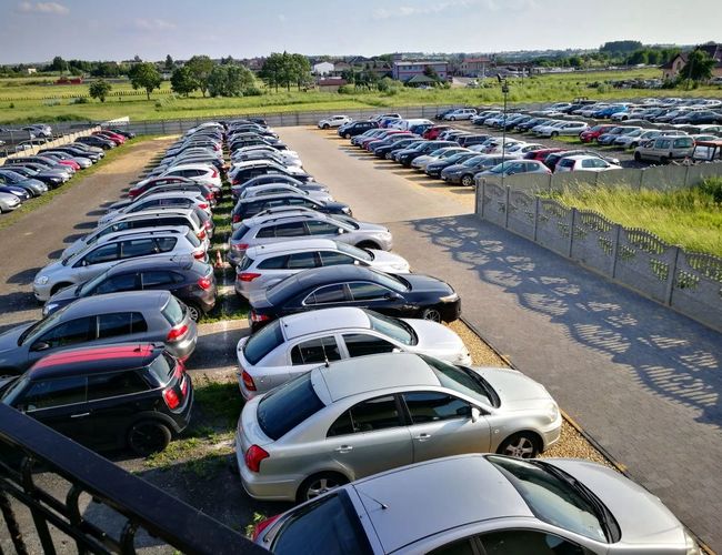 Parking Darex - Aparcamiento lleno de coches, organizados en filas. El terreno está cercado y tiene caminos de asfalto de acceso.