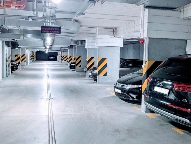 Odlot Garage - Estacionamiento subterráneo con espacios para coches. Iluminado y marcado con franjas amarillas y negras.