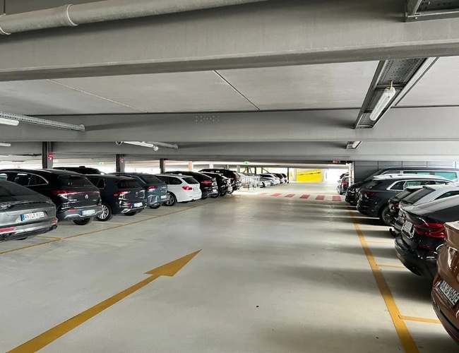 Jasne i przestronne wnętrze parkingu P4 na lotnisku Stuttgart z wyznaczonymi miejscami postojowymi oraz wygodnym dojazdem do terminali lotniczych.