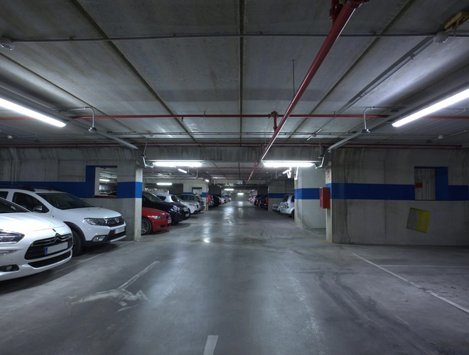 Oliveral Parking - En el garaje subterráneo hay coches estacionados. El área está bien iluminada. En el medio hay un espacio para conducir.
