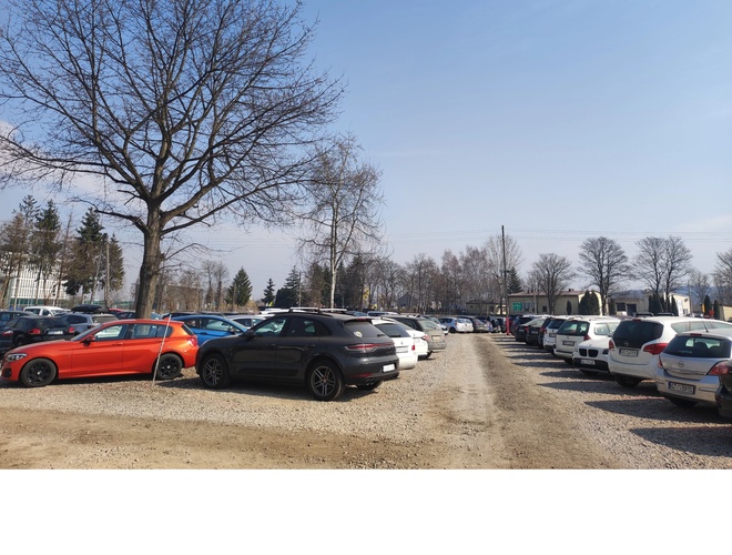 Krk Parking Lotnisko - Na parkingu stoją samochody. Jest dużo miejsc dostępnych. Drzewa otaczają teren.