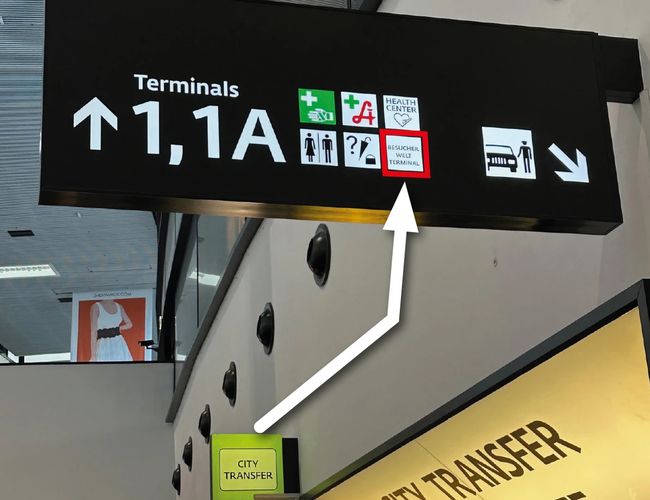 Aparcamiento Parktiger Transfer - Las señales indican la dirección hacia las terminales. Las flechas y el texto señalan el camino hacia los transferencias urbanas.