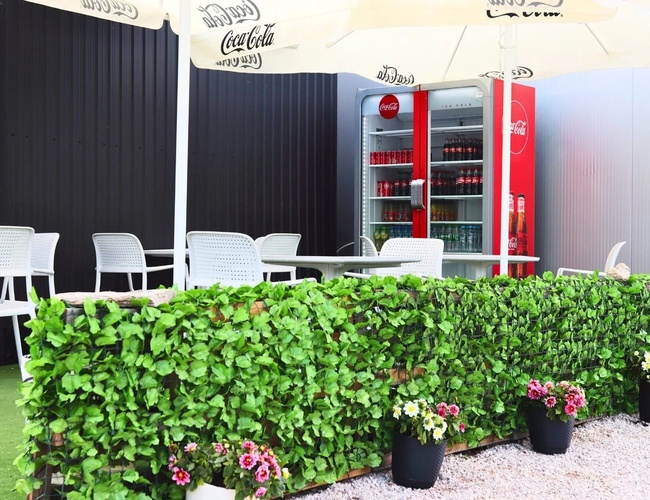 Najlepšia parkovacia séria A – zóna na oddych s slnečníkmi a stolíkmi. Na území sa nachádzajú biele stoličky a chladnička s nápojmi.