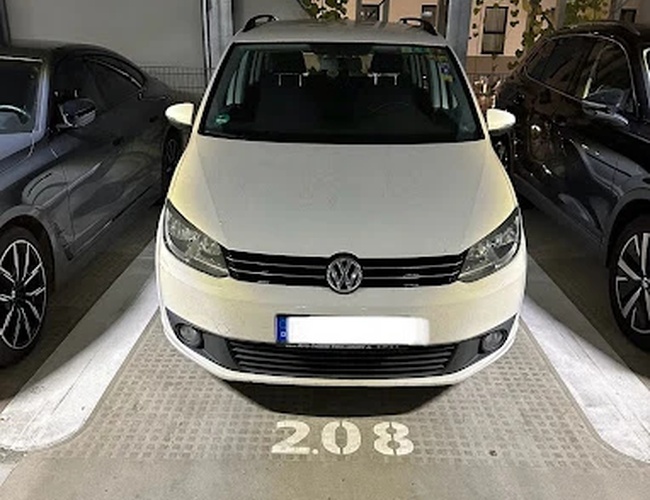Parking Marspark Covered Valet – Samochód stoi na zadaszonym, oświetlonym miejscu. Obok są inne auta. Podłoga ma wyraźne oznaczenie numeru miejsca.
