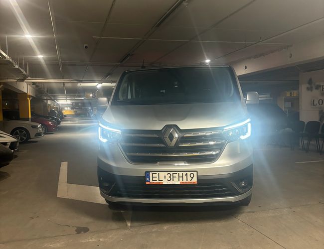 Parking MarcelinPark – Samochód stoi na zadaszonym miejscu. Reflektory są włączone. Przestrzeń jest dobrze oświetlona.