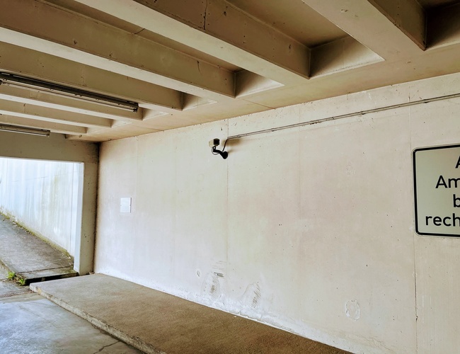 Royal Valet Parking – Kryté miesto s kamerovým systémom. Vedľa steny s tabulkou. Výjazdová cesta na ľavej strane.