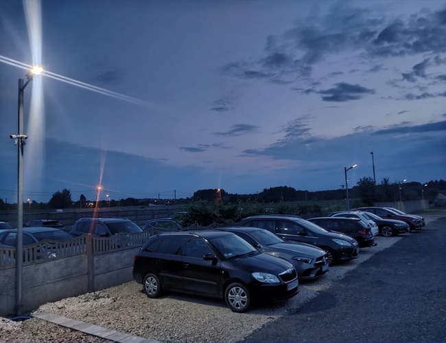 Plac parkingowy wraz z zaparkowanymi pojazdami z innej strony