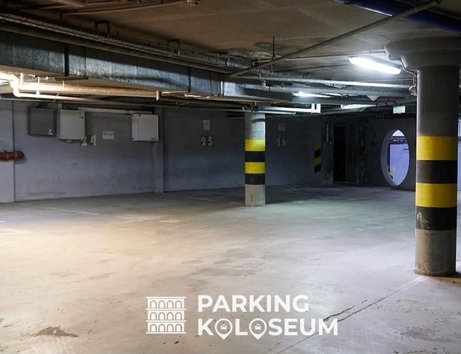 Parkering Colosseum - Underjordisk parkeringsplass. Betong støtter beskytter området. Belysningen er lys.
