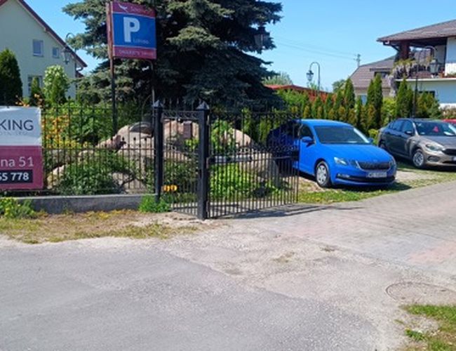 Parking Park24 – El área está cercada y bien señalizada. La entrada se realiza a través de una puerta. En el recinto estacionan coches.