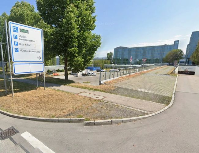 Tablica informacyjna kierująca do parkingów lotniskowych.