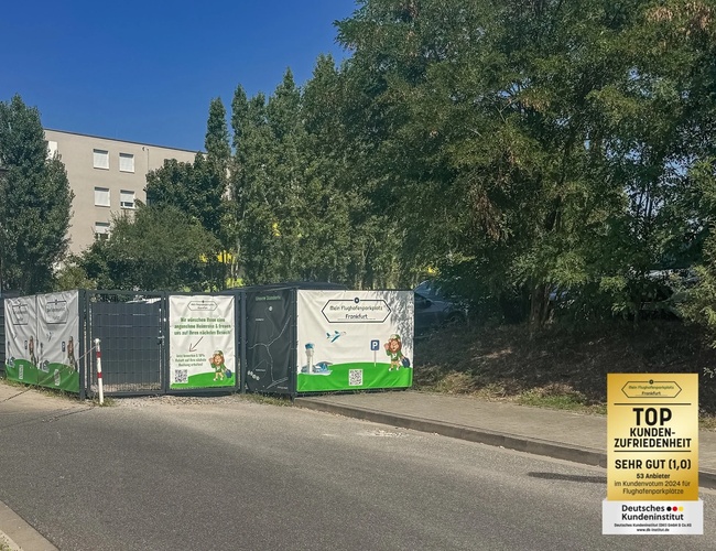 Parking Mein-Flughafenparkplatz-Frankfurt P1. Droga dojazdowa do parkingu, ogrodzenie z banerami reklamowymi po prawej stronie.