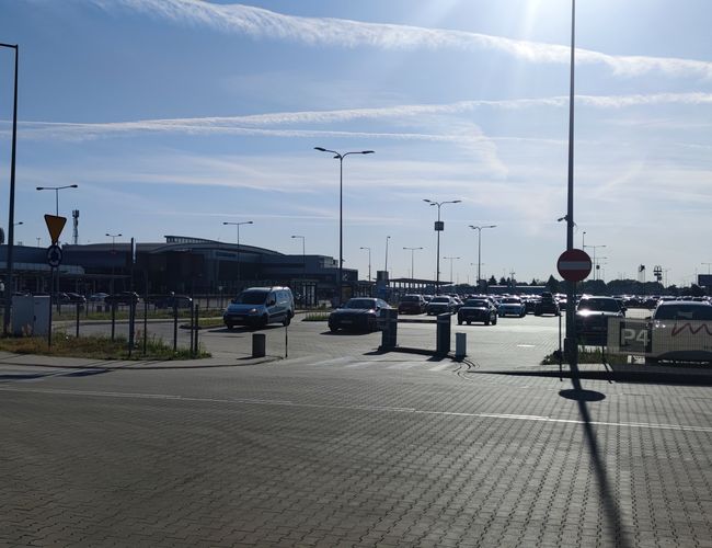 Офіційна парковка P4 — велике асфальтоване місце, заповнене транспортними засобами. Територія освітлена ліхтарями, із помітним входом до будівлі.