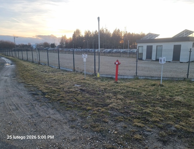 Plac parkingowy z utwardzoną nawierzchnią i zaparkowanymi samochodami