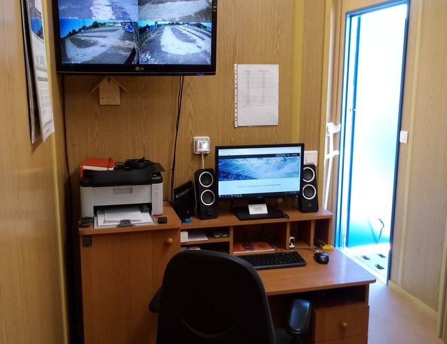 Estacionamiento Bastión - Sala con escritorio y equipo de monitoreo. En las pantallas se ven las cámaras. Al lado hay una impresora en la estantería.