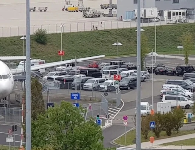 Widok na oficjalny parking NORD przy lotnisku Cologne Bonn z licznymi miejscami postojowymi oraz terminalem widocznym w tle, przeznaczony dla osób korzystających z parkingu lotniskowego.