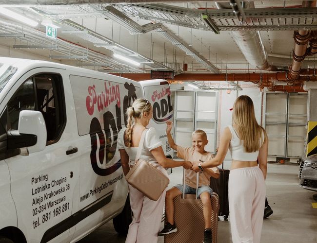 Odlot Garage - Wewnątrz podziemnego parkingu stoją zaparkowane samochody. Miejsca są oznaczone numerami. Teren jest dobrze oświetlony.