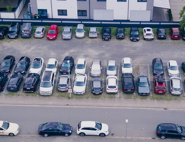 Parking Mein-Flughafenparkplatz-Frankfurt P3. Zdjęcie lotnicze ukazujące kilkanaście zaparkowanych pojazdów na dużym placu