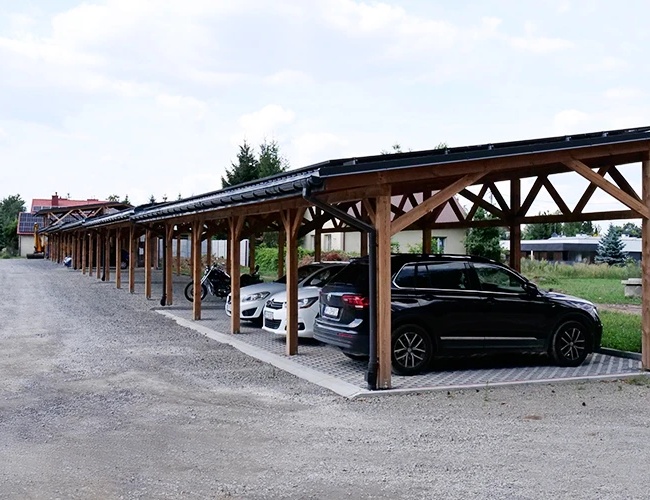 Zelené parkovisko Kompleks Dwór Ostoya - Kryté parkovisko s automobilmi a motocyklom. Areál je spevnený a nachádza sa na otvorenom priestranstve.