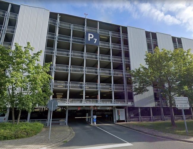 Frontowa część parkingu P7 z otwartą konstrukcją, oznaczeniem strefy oraz łatwym dostępem do miejsc parkingowych dla podróżnych.