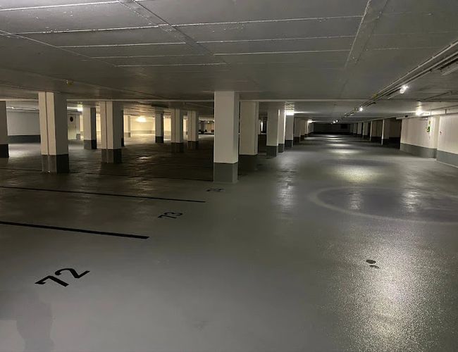 Parking Park2Travel Valet Garage - szeroka, oświetlona przestrzeń z oznaczonymi miejscami. Wnętrze jest czyste i dobrze zorganizowane.