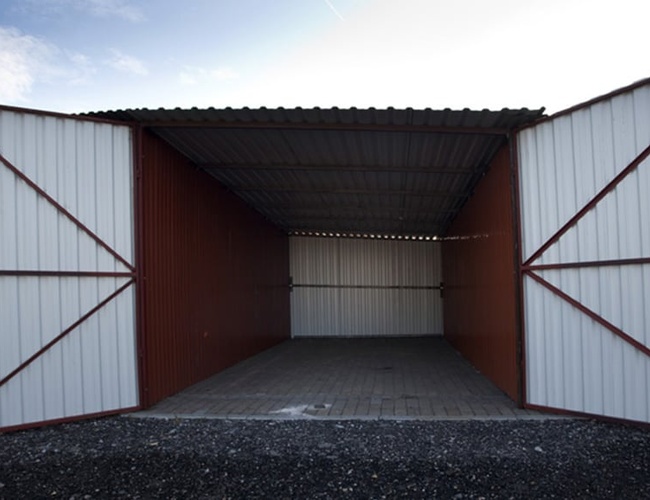 PERI Parking Garaże Premium - Garaż z otwartymi drzwiami. Duża, zadaszona przestrzeń z betonową podłogą.