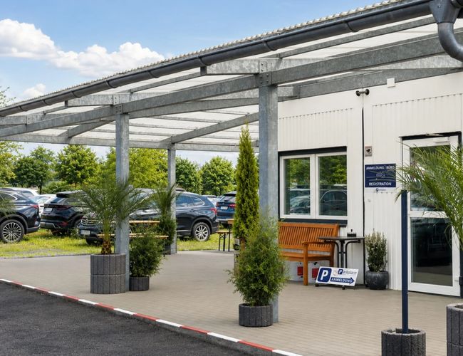 Parking myParkplace – na zdjęciu dwie plastikowe podstawki z wizytówkami myParkplace. W tle widać zieloną roślinę. Wizytówki stoją na drewnianym biurku.