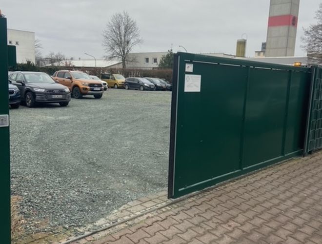 Parkoló Park-Box-Frankfurt Valet - A terület kerítéssel van körülvéve. Nyitott bejárati kapuk. Látható parkoló autók, főleg a háttérben.