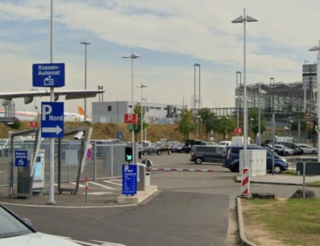 Wjazd do oficjalnego parkingu NORD na lotnisku Cologne Bonn z czytelnym oznakowaniem, szlabanami oraz wygodnym dojazdem do terminali pasażerskich.